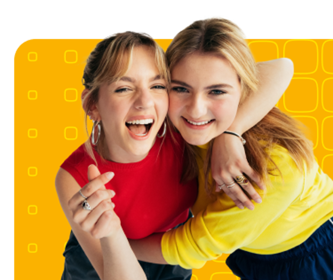 Two young women hugging and smilling.
