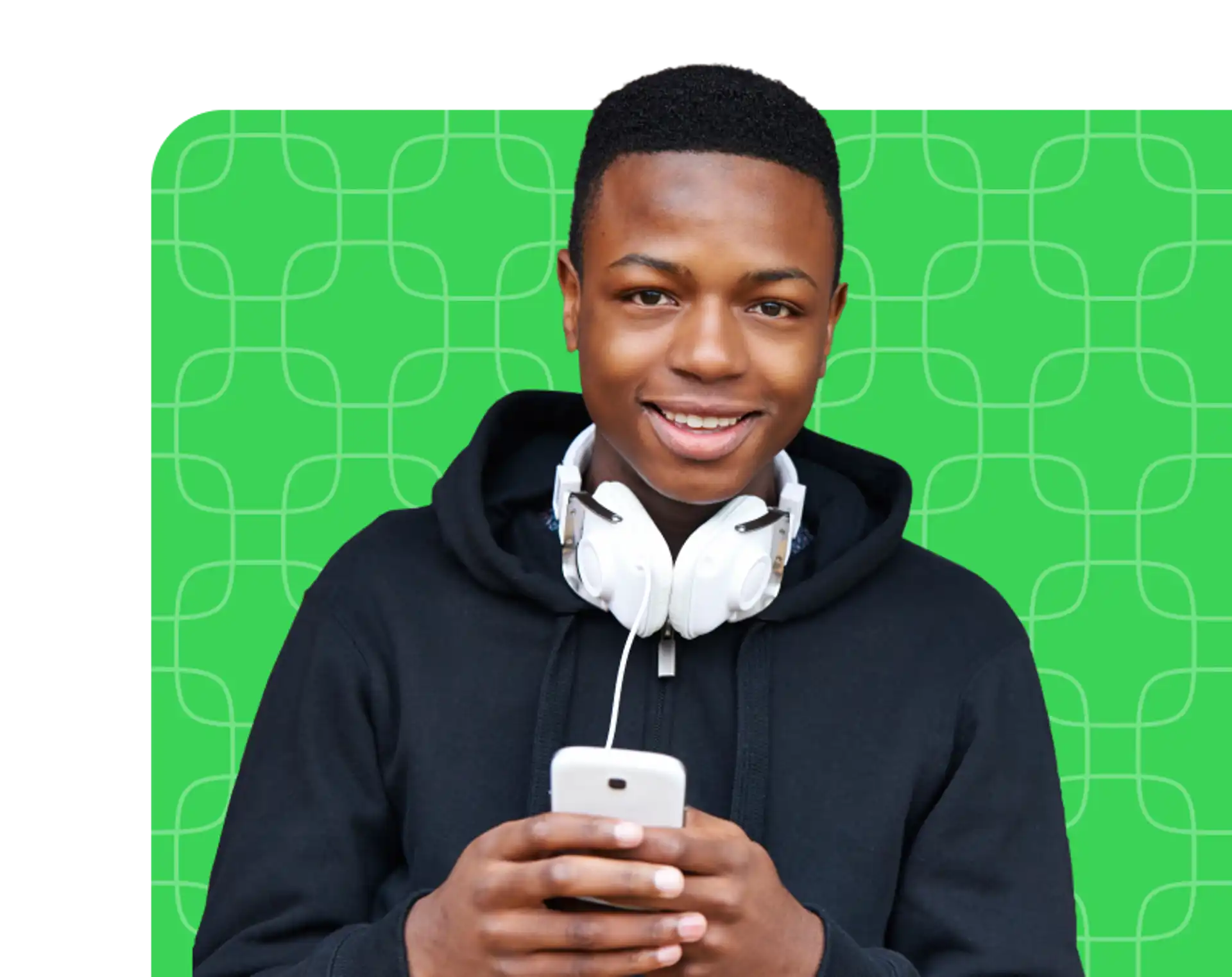 Young man with headphones around his neck smiling and holding his phone